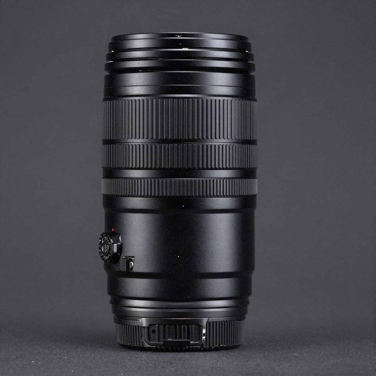 A long black camera zoom lens standing upright