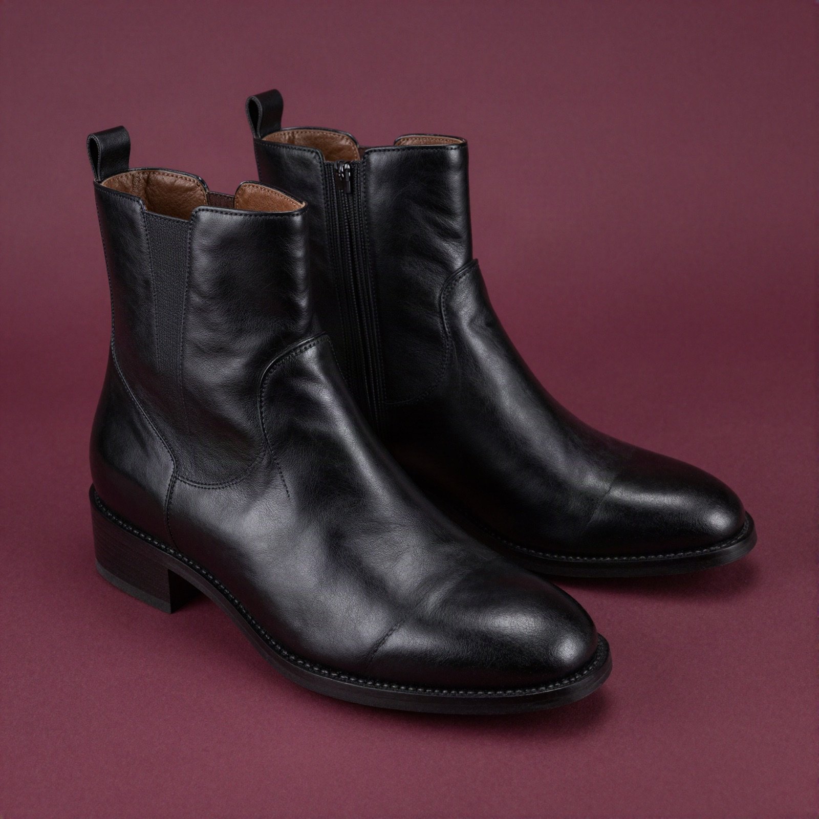 Black leather ankle boots on a plum background
