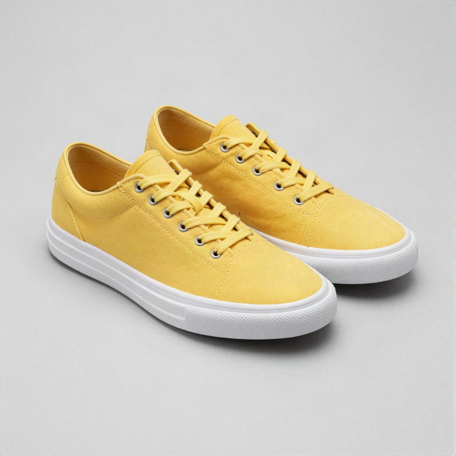 A pair of bright yellow canvas sneakers with white soles