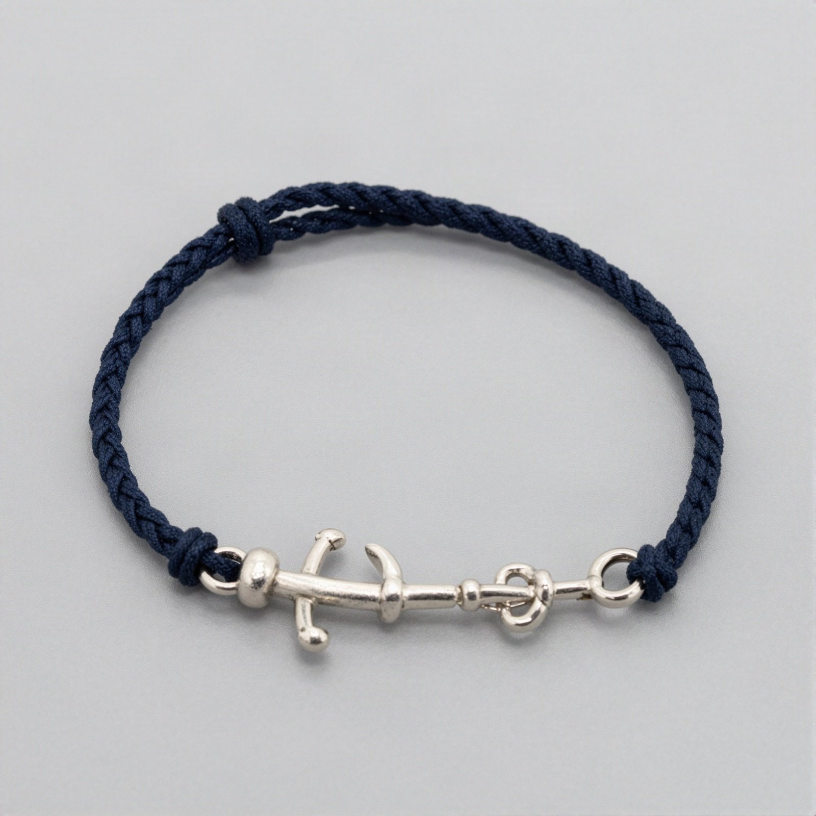Silver anchor bracelet on a braided navy cord
