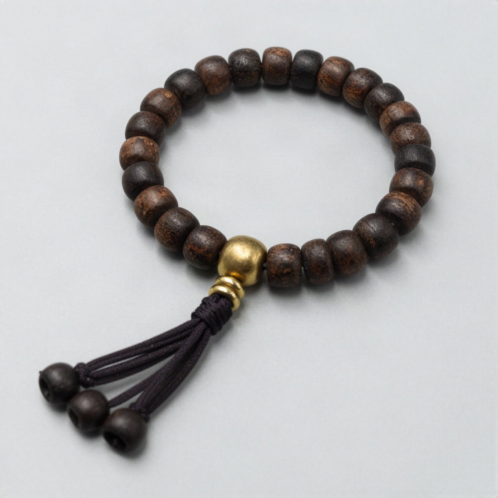 Wooden bead bracelet with a brass bead and tassel