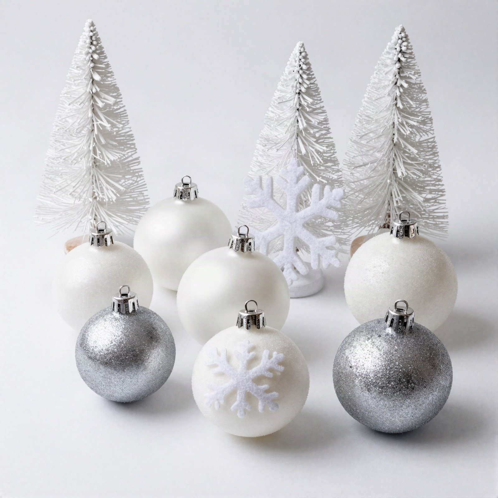 White and silver snowflake baubles with frosted mini trees