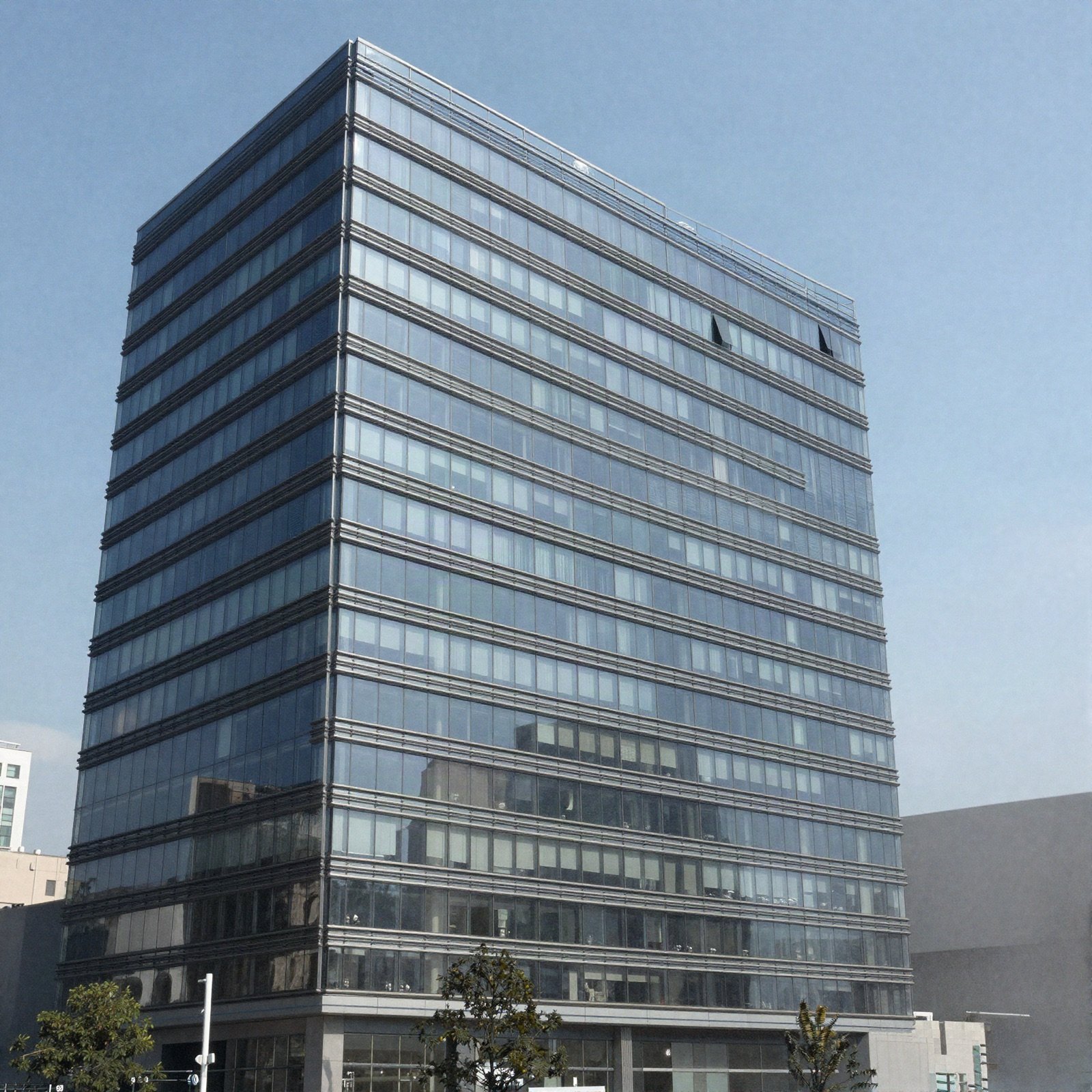 Glass office tower against a blue sky