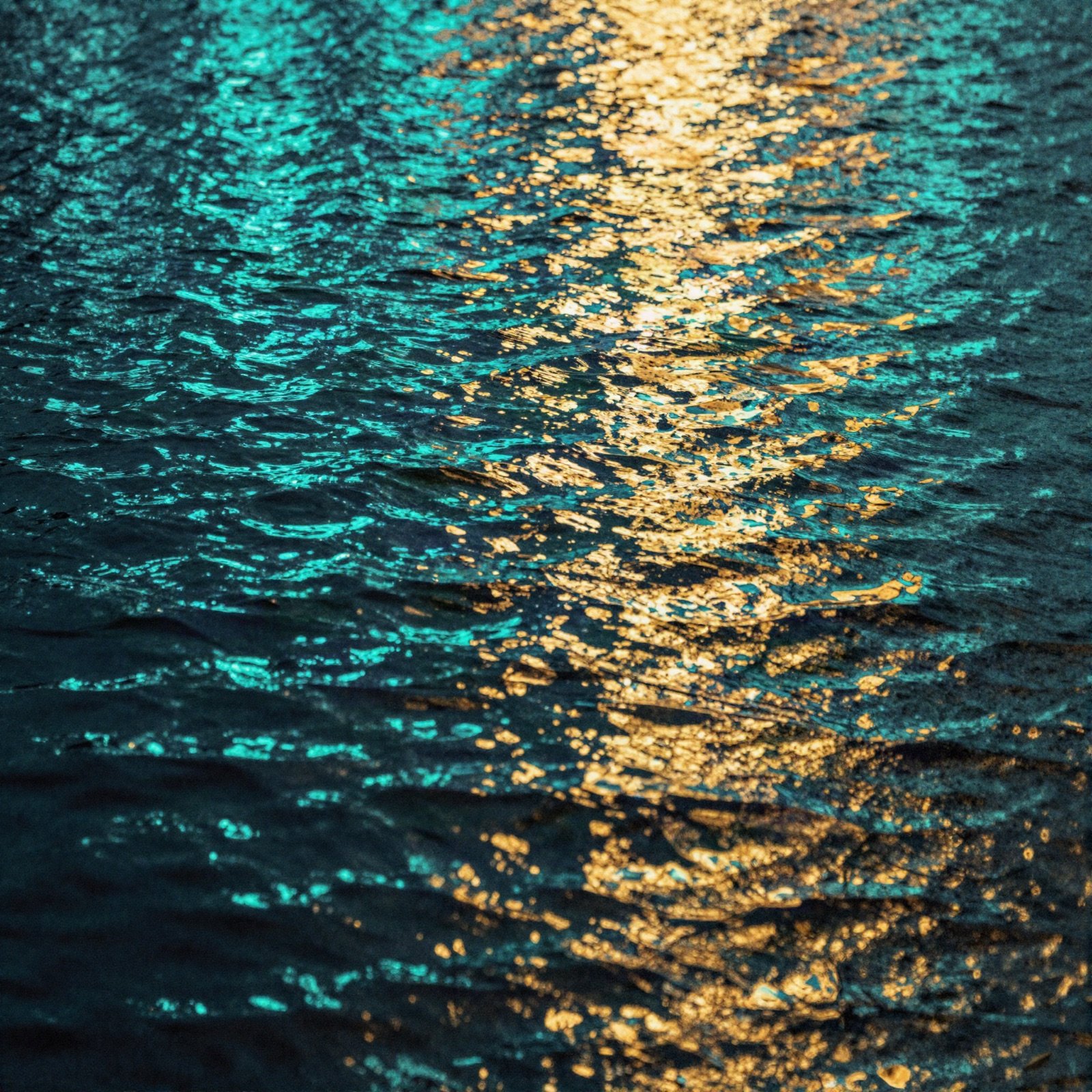 Album artwork of teal and gold light rippling on dark water