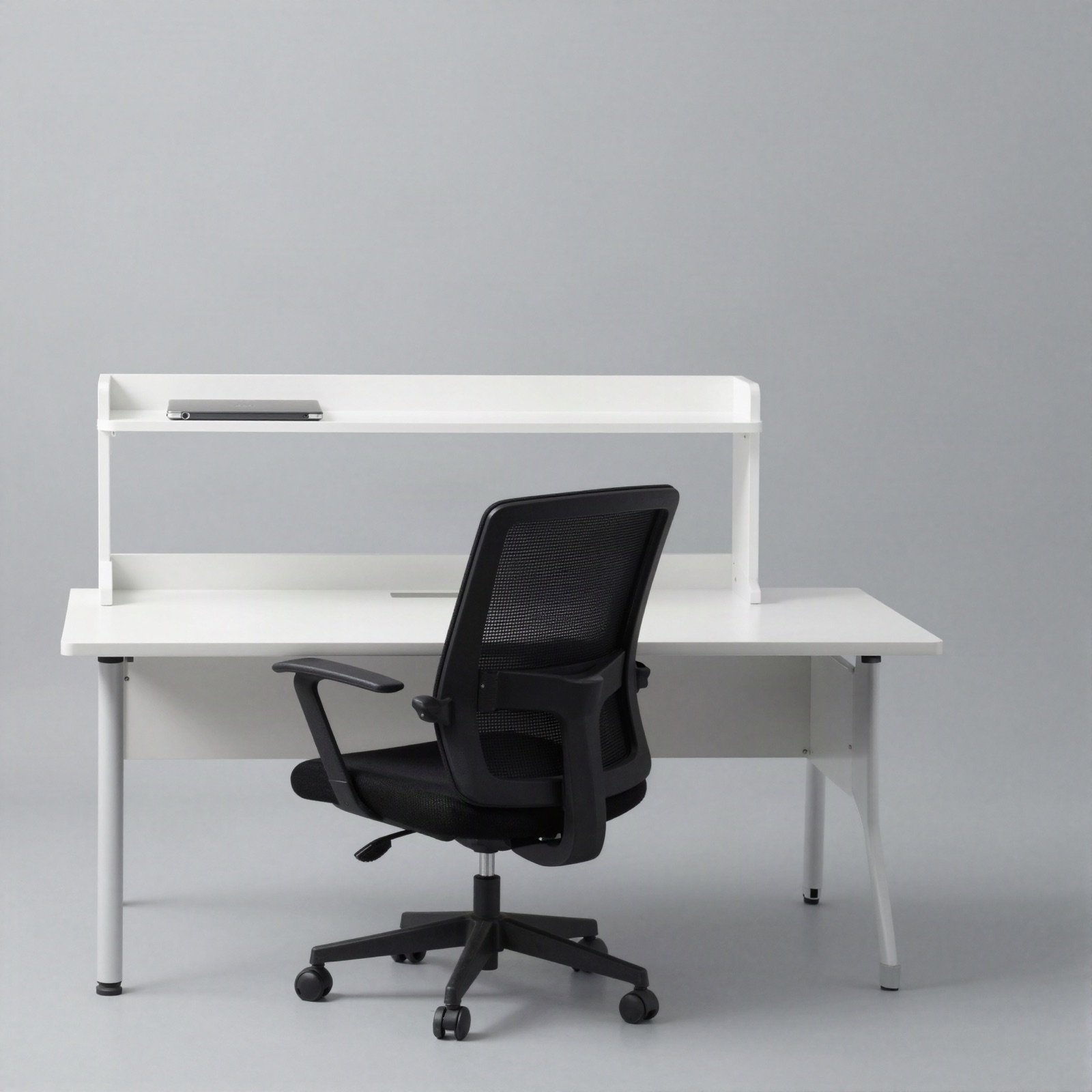 White computer desk with a shelf and a black mesh office chair