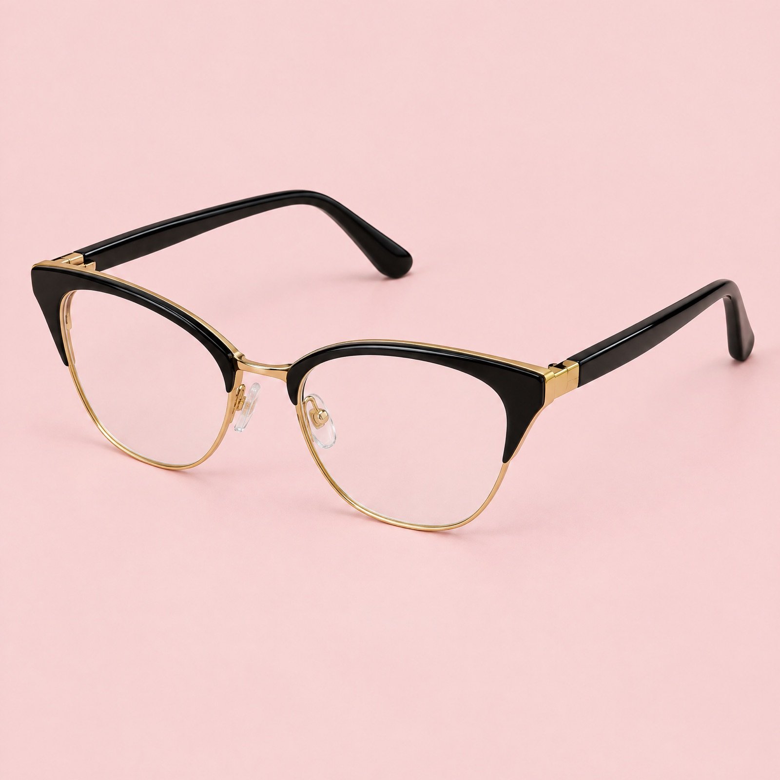 Black and gold cat-eye reading glasses on a blush pink background
