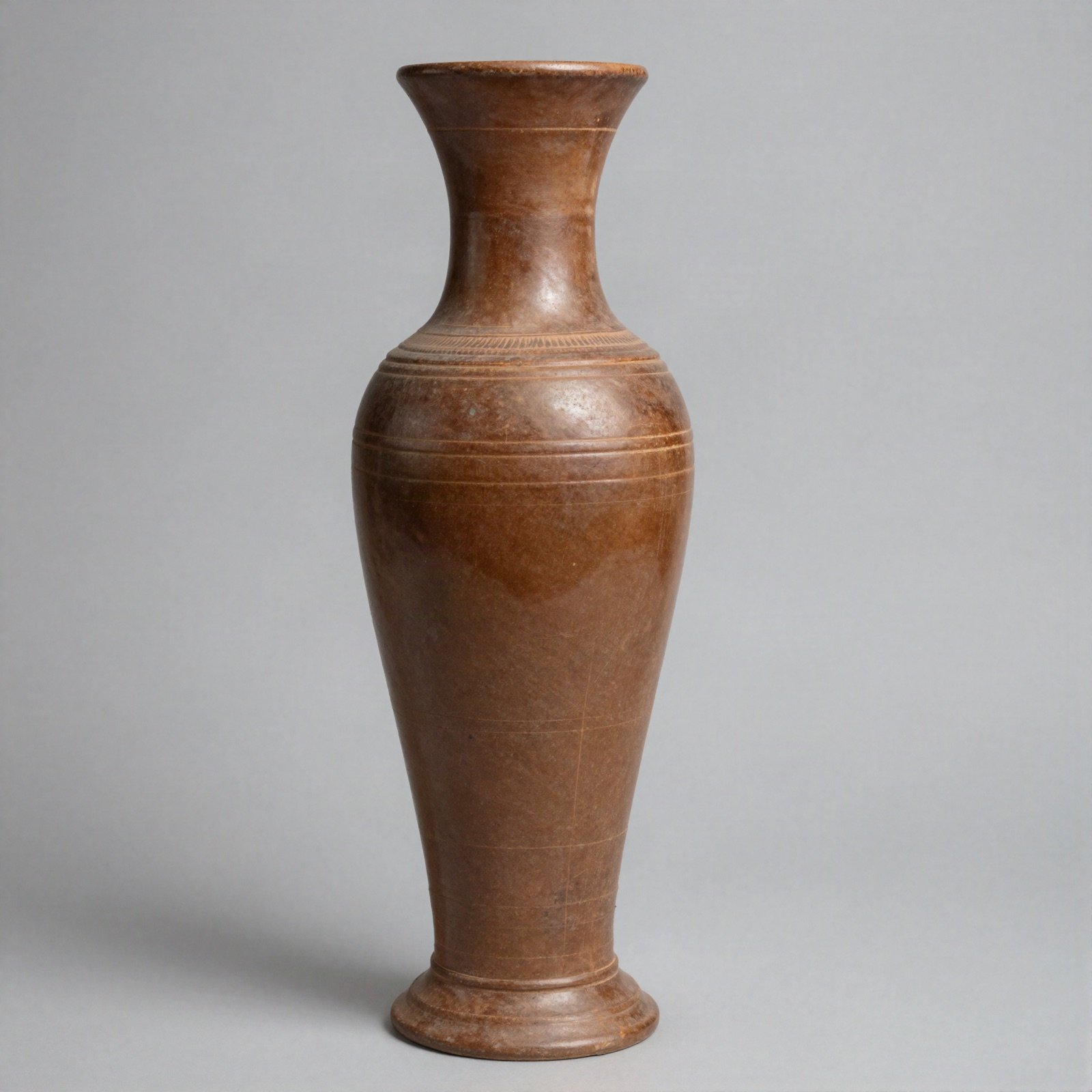 A tall brown ceramic vase