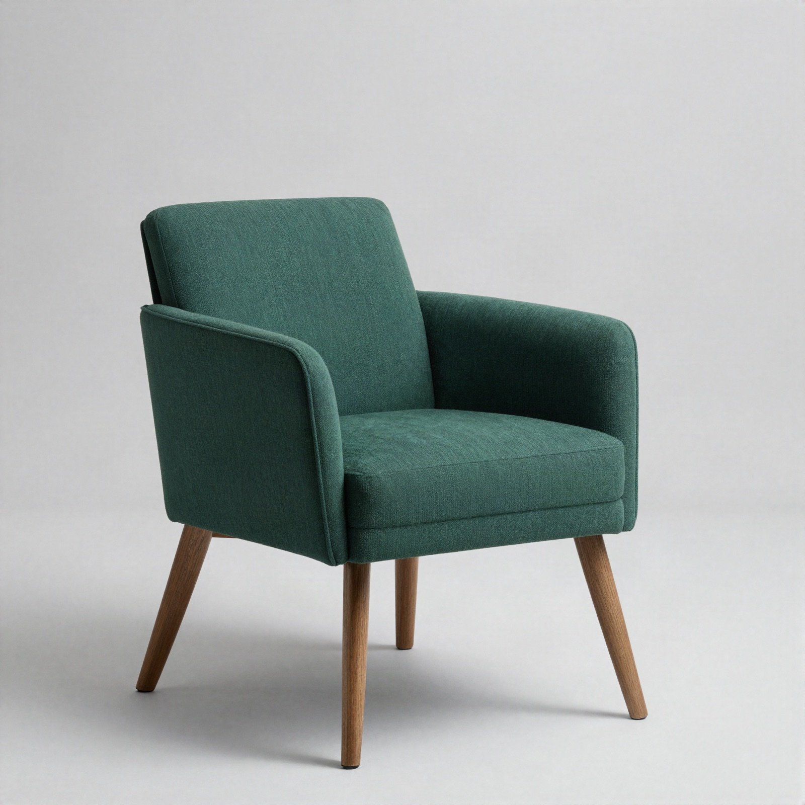 An emerald green fabric armchair with wooden legs