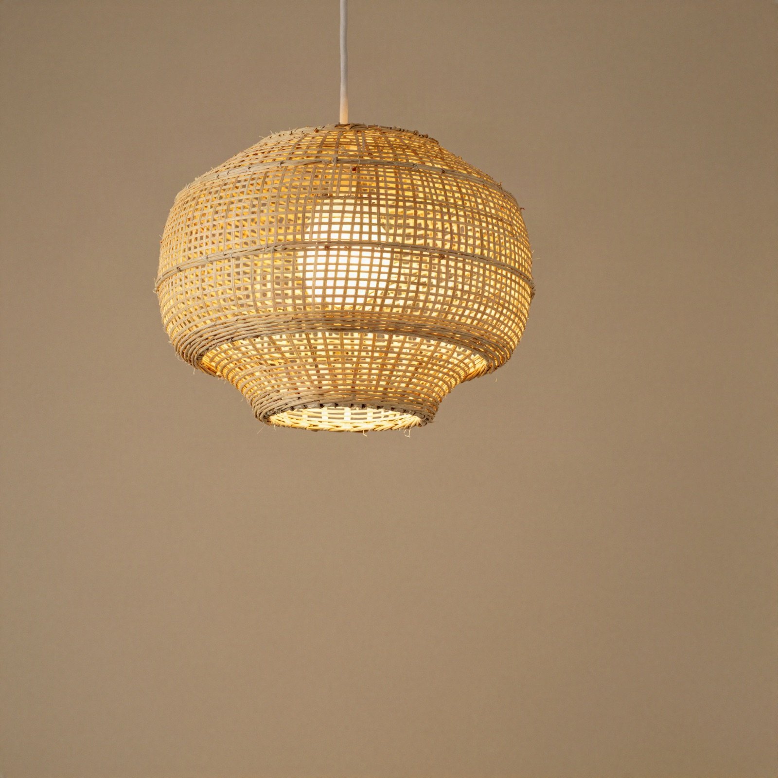 Round woven pendant lamp hanging from a cord