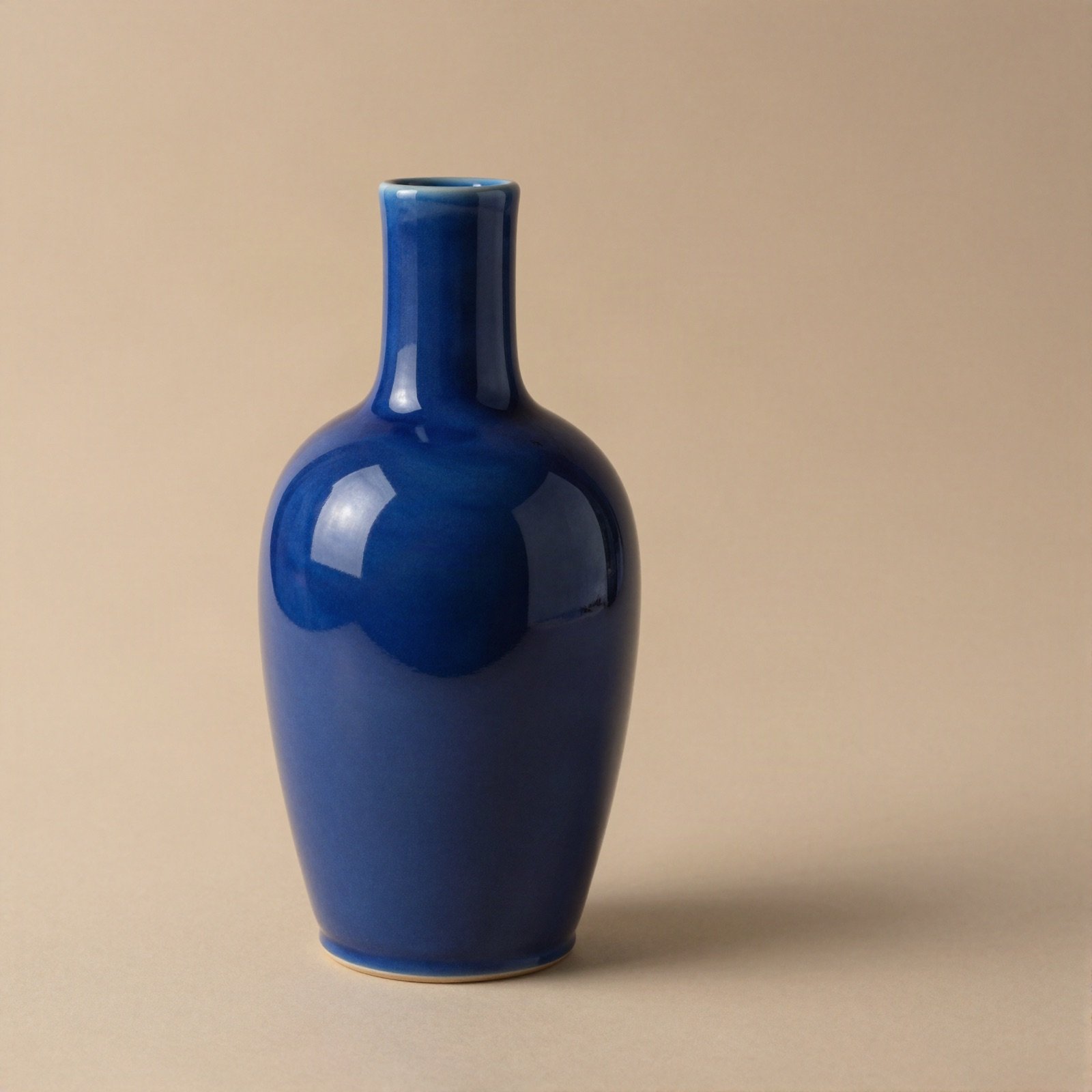 Glossy cobalt blue bottle-shaped ceramic vase