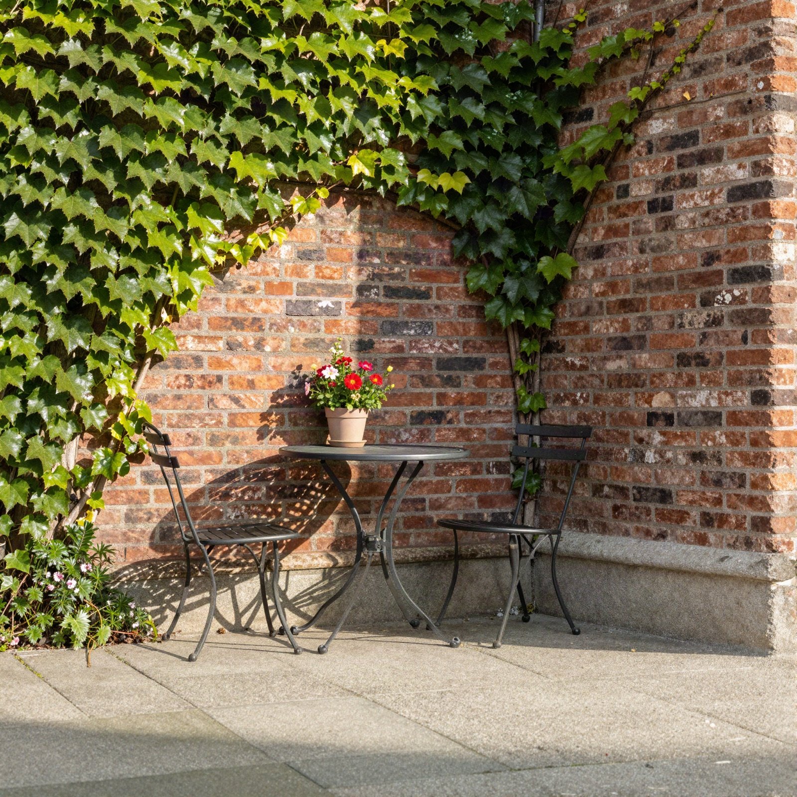 Ivy-covered brick courtyard with a bistro table