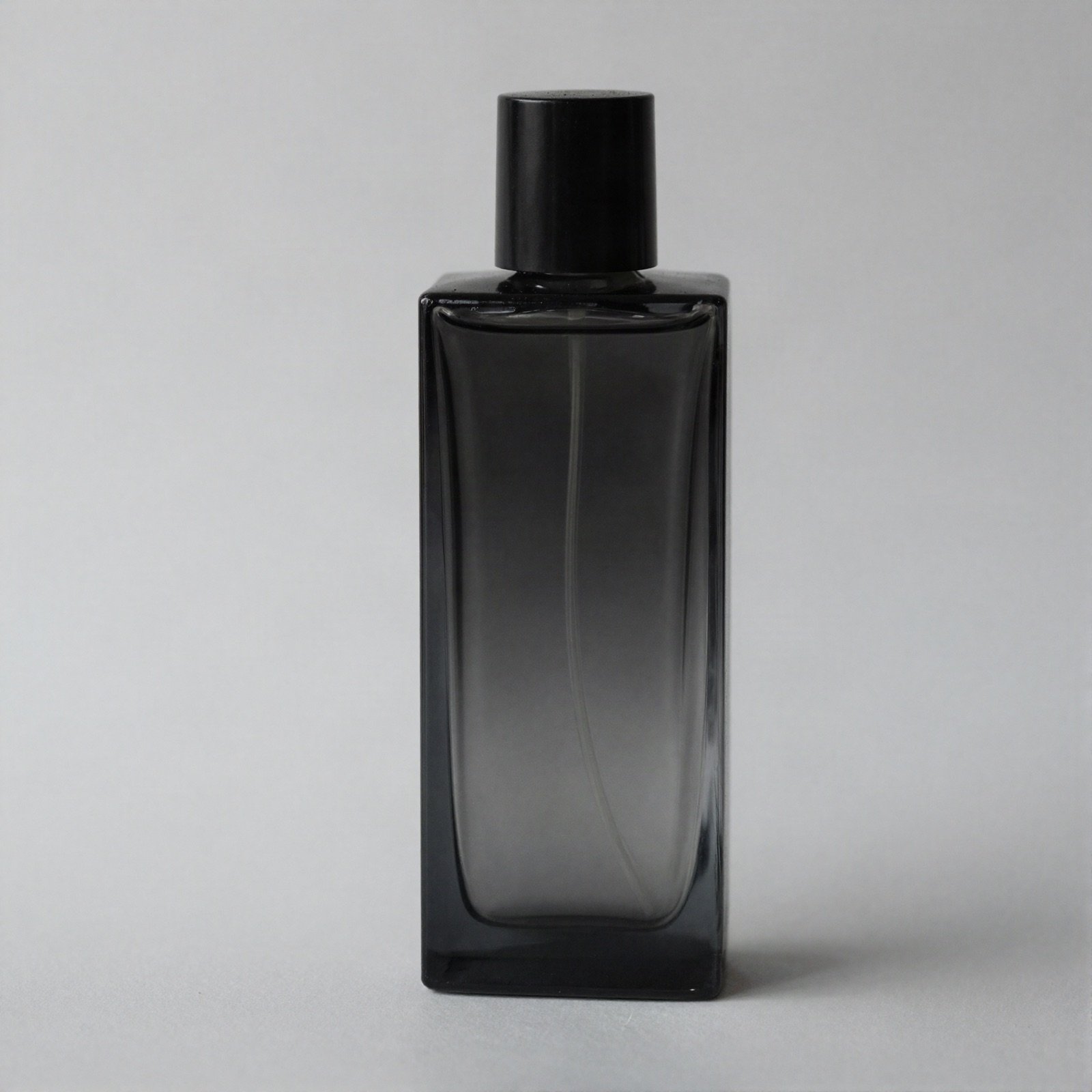 Tall smoky black glass perfume bottle with a black cap