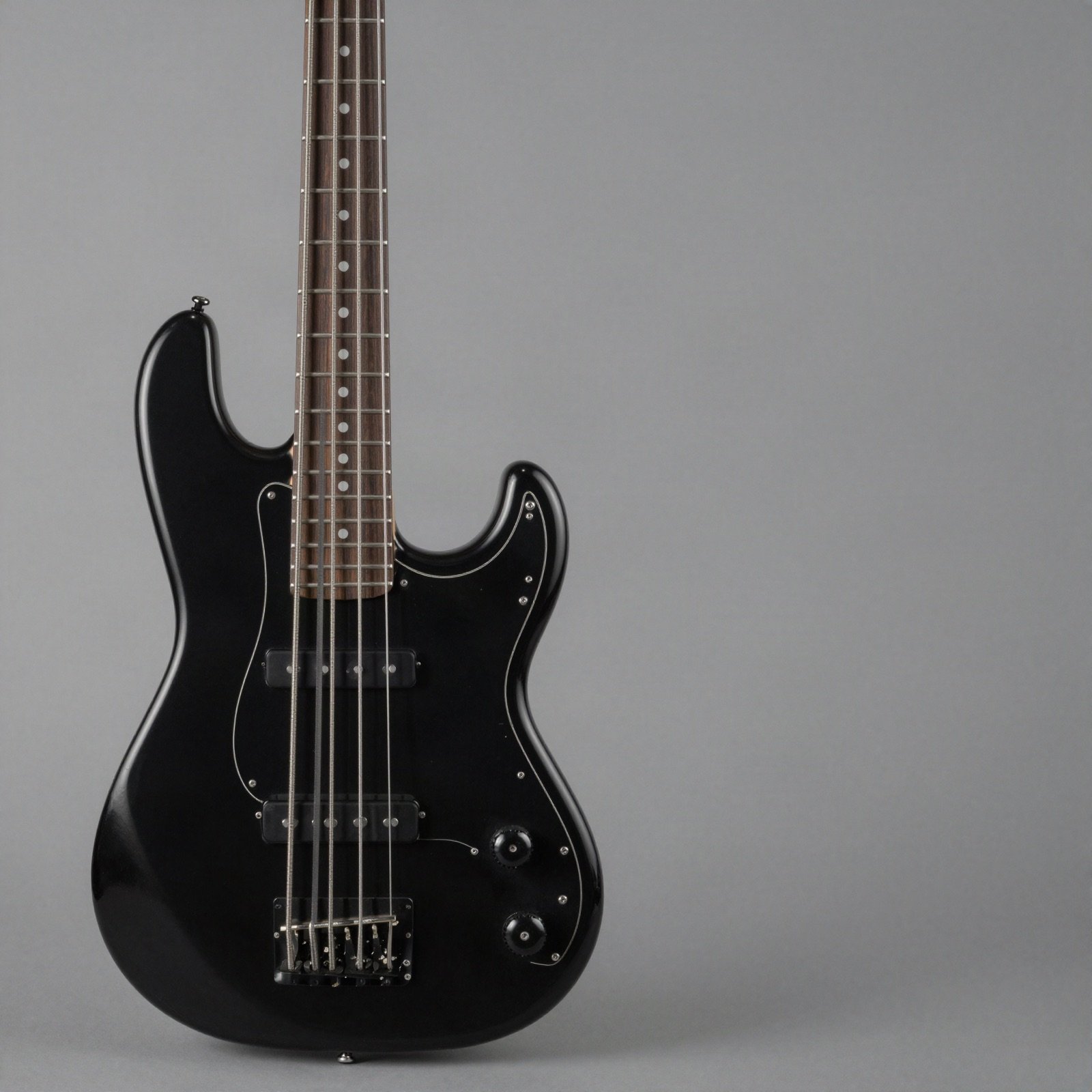 A satin black four-string bass on a plain grey background