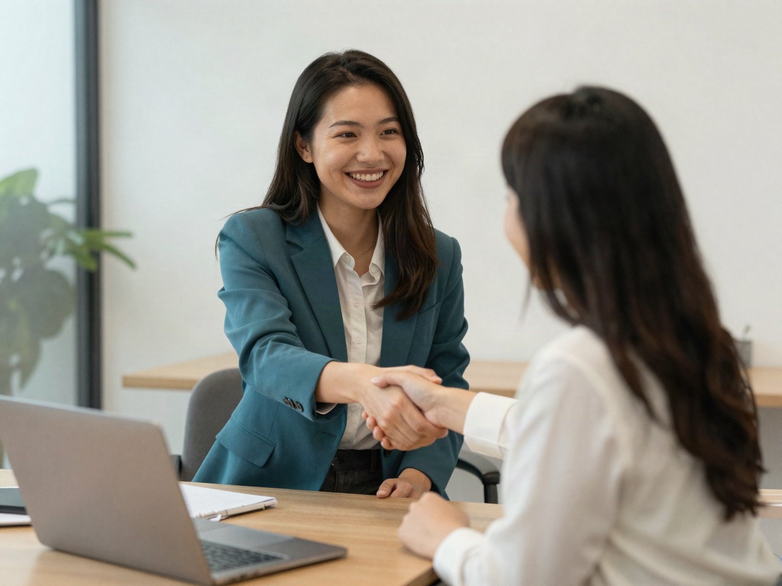 An agent shaking hands with a client in the office