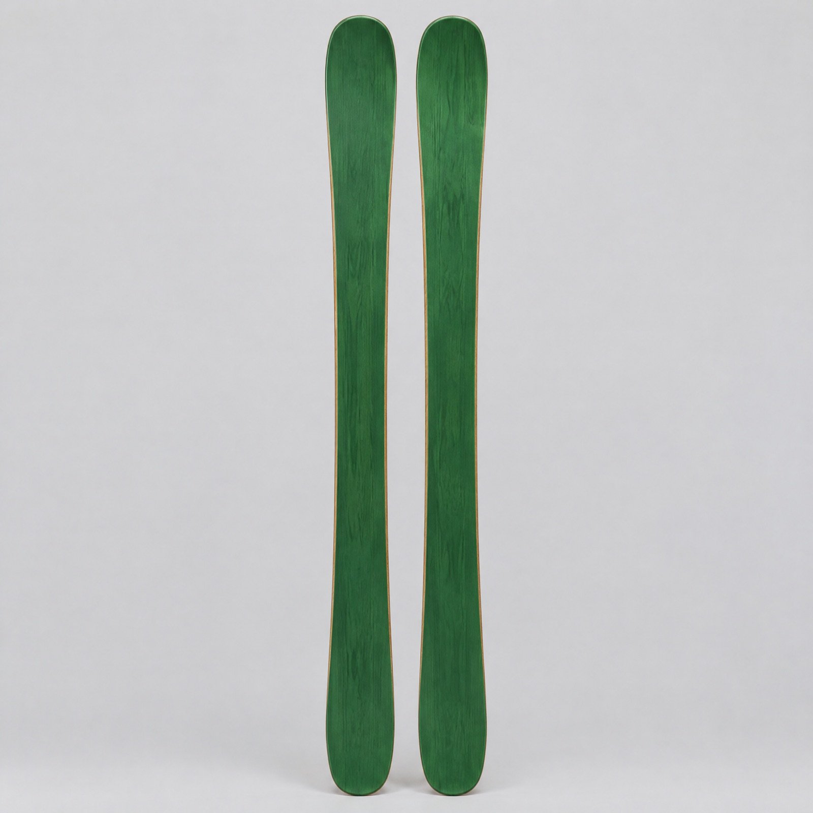 A pair of green all-mountain skis standing upright on a grey background