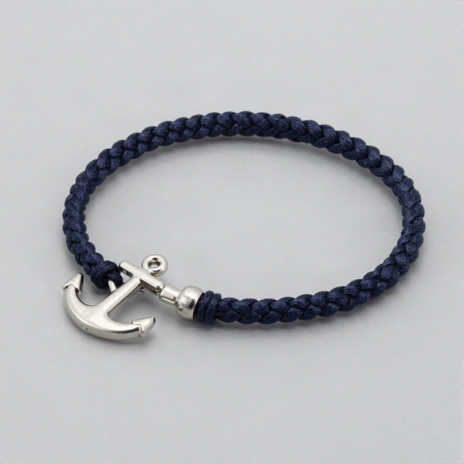 A navy braided cord bracelet with a silver anchor clasp