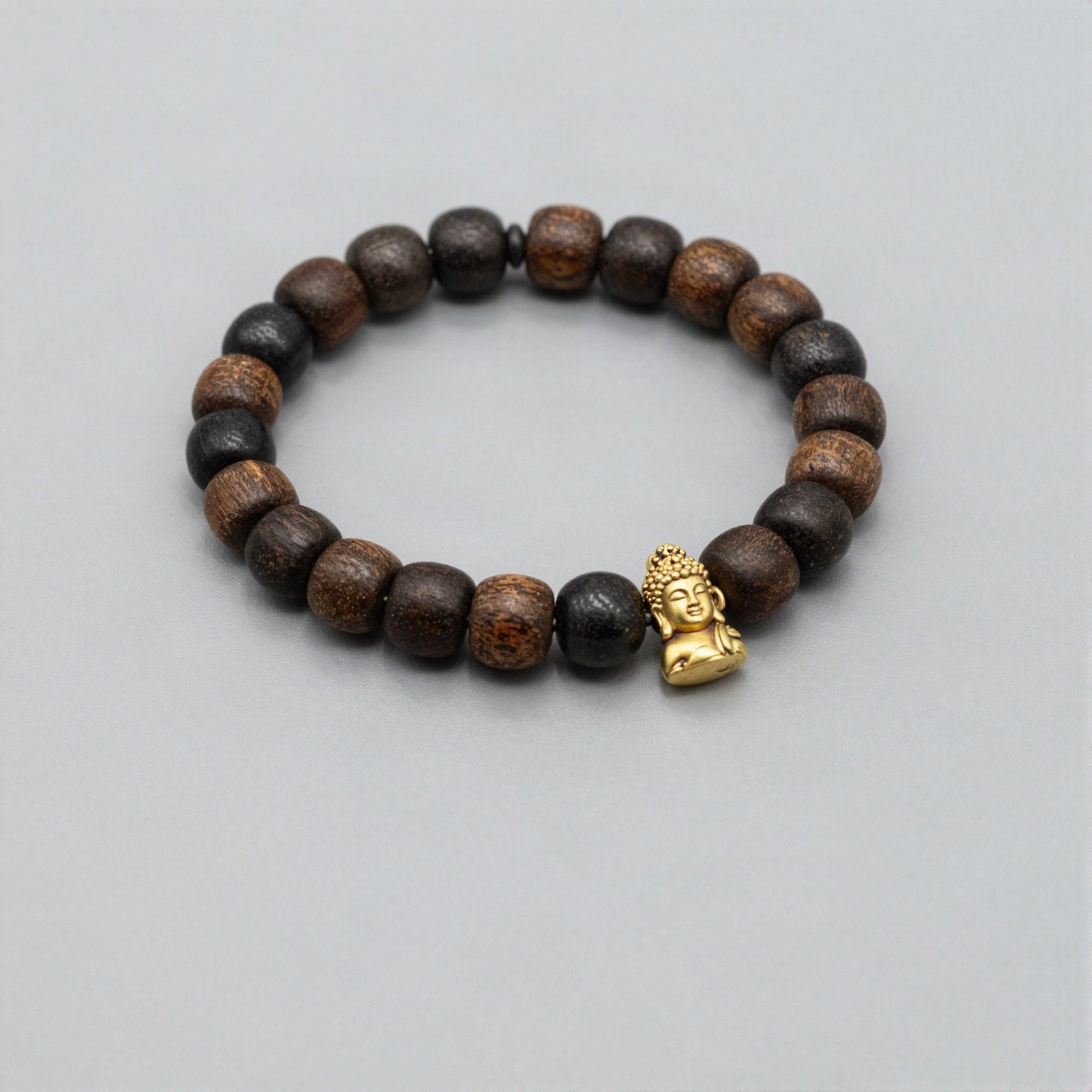 A wooden bead stretch bracelet with a small gold Buddha charm