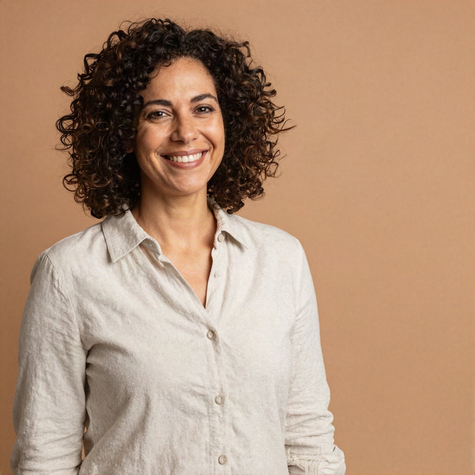Portrait of a smiling woman with curly hair in a linen shirt