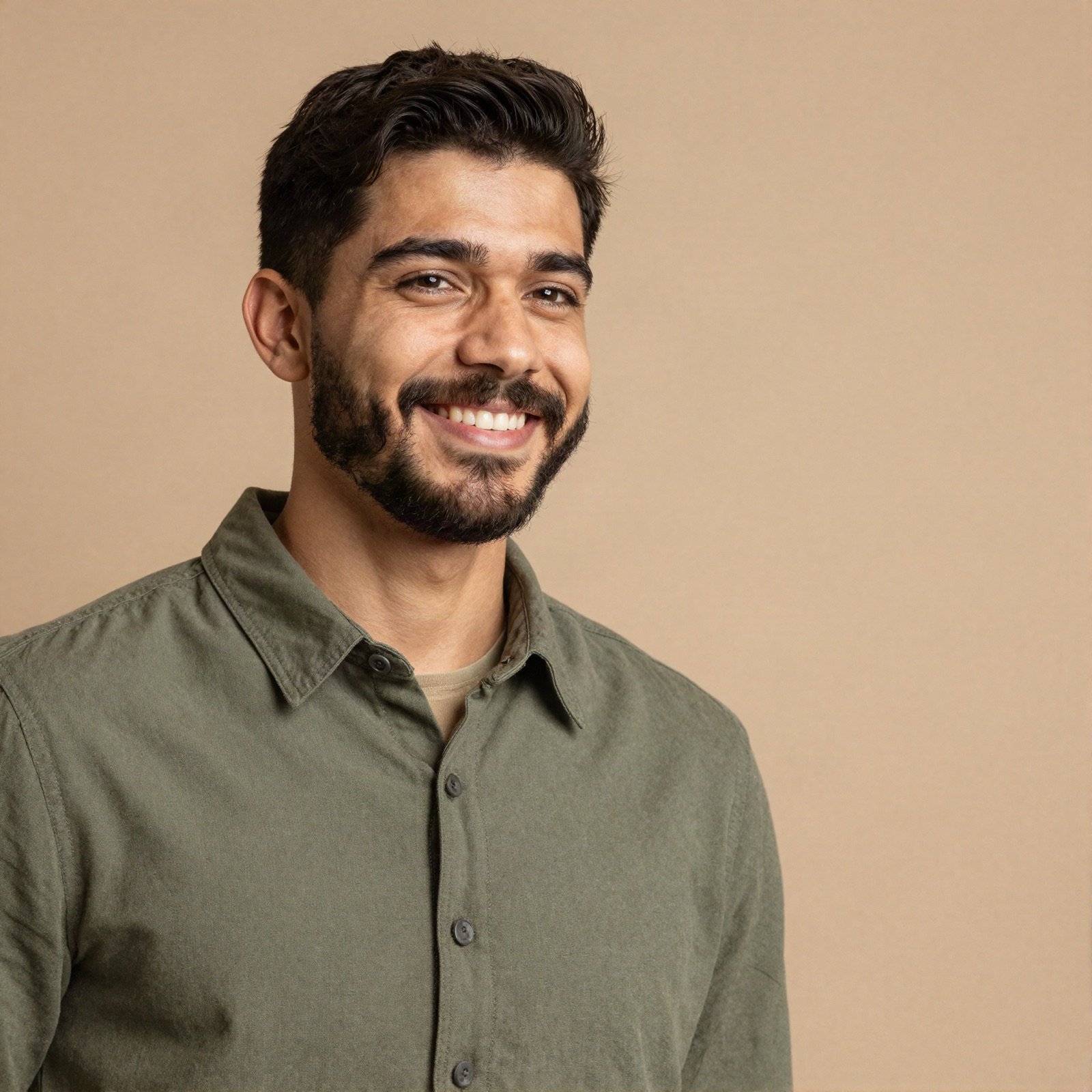 Portrait of a smiling young man with a beard in an olive shirt