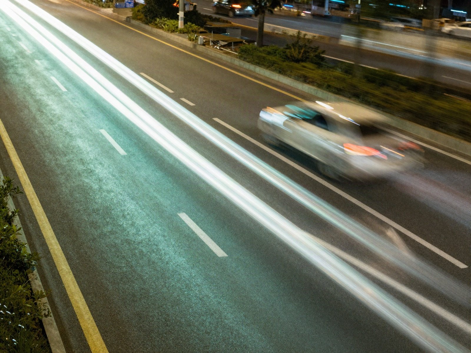 Light trails of fast traffic on a highway at night
